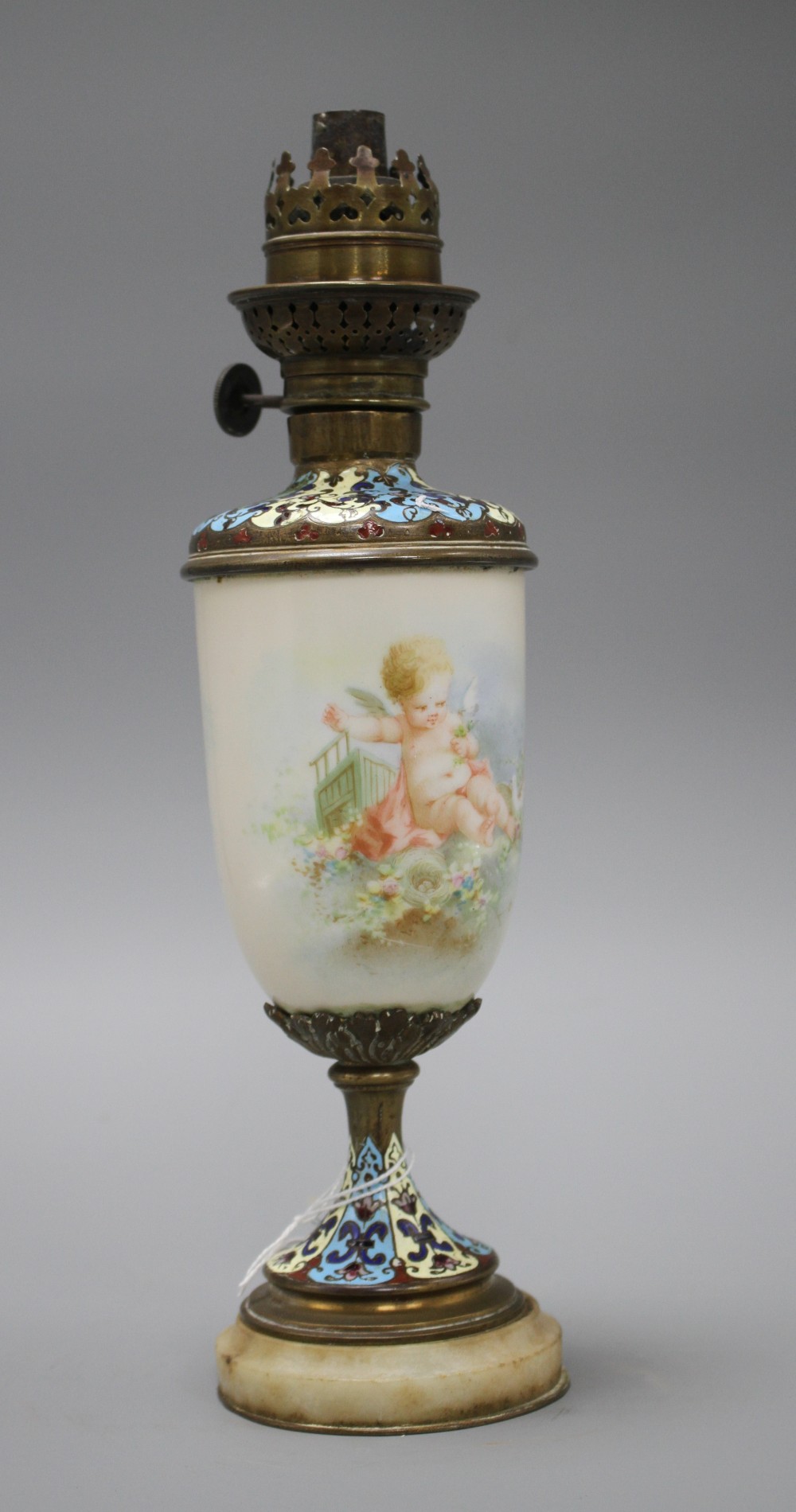 An early 20th century French champleve enamel bronze and ceramic lamp base, painted with a cherub, height 28cm